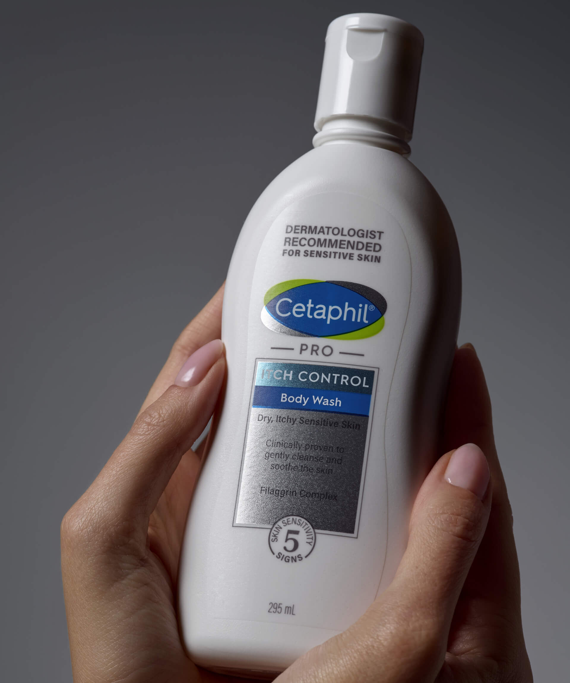 Trzymane w dłoniach opakowanie emulsji do mycia Cetaphil Itch Control.